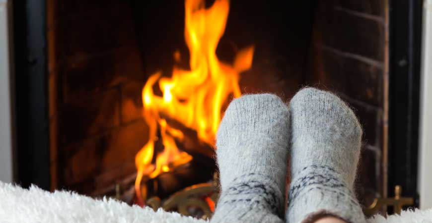 two feet with socks in front of fireplace | ana Valenzuela house cleaning services